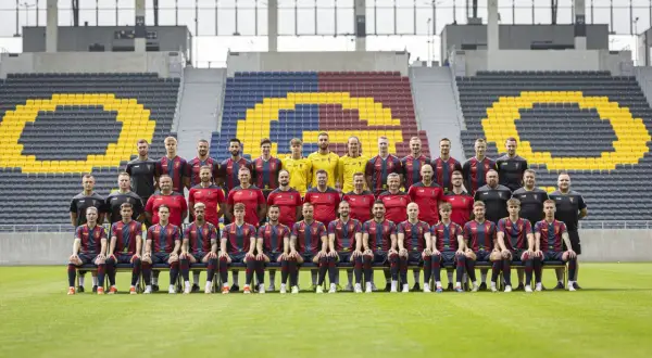 Drużyna Pogoń Szczecin dzisiaj pozuje do zdjęcia na tle stadionu.