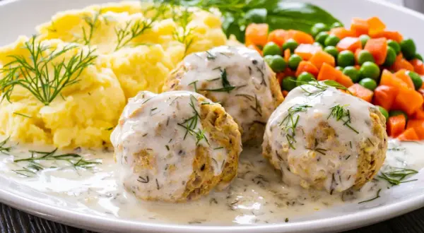 Pyszne pulpeciki w kremowym sosie, podane z puree ziemniaczanym i warzywami. Idealny pomysł, jak zrobić sos do pulpetów, by danie było wyborne!