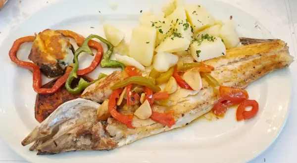 Lubina a la bilbaina con patatas y pimientos asados. Un plato delicioso y saludable.