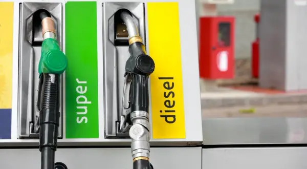 Pistolets de pompe à essence, l'un vert pour le super, l'autre noir pour le diesel. Choix entre essence ou diesel.