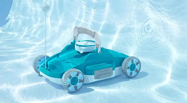 Robot do czyszczenia basenu porusza się po śliskim dnie basenu, gdzie światło tworzy na wodzie faliste wzory.
