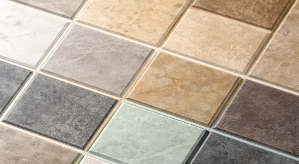 Szeroki wybór płytek ceramicznych w różnych odcieniach i wzorach, z widoczną fugą z trasem.