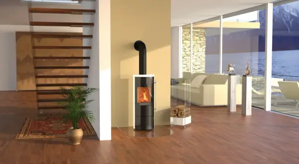 Moderner Kaminofen eines deutschen Kaminofenherstellers mit brennendem Feuer. Daneben ein Stapel Holz.