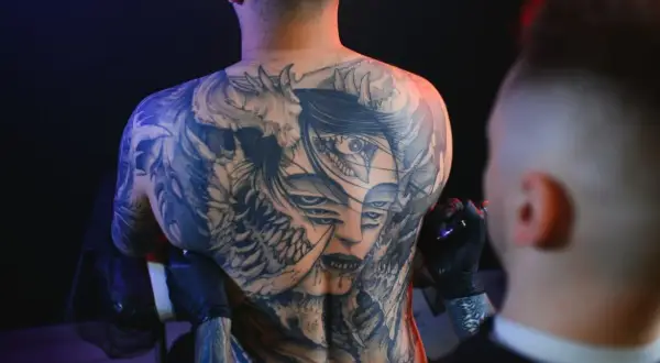 Męski tatuaż na barku z wieloma oczami i demoniczny motyw.