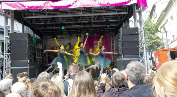Ballettgruppe auf einer Bühne bei Veranstaltungen im Bergischen Land. Ein Publikum filmt die Darbietung.