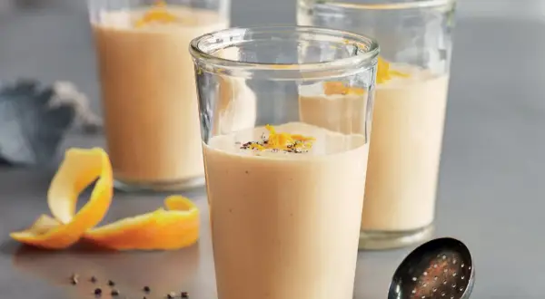 Tre glas med krämig apelsinsmoothie, toppad med rivet apelsinskal och pepparkorn. Ett perfekt smoothie recept för en uppfriskande start.