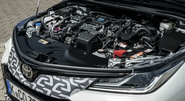 Silnik hybrydowy Toyoty Matrix, pełen przewodów i elementów, gotowy do pracy.