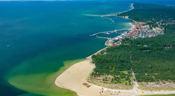 Widok z lotu ptaka na Hel – polskie egzotyczne miejsca z piaszczystą plażą, lasem i portem.