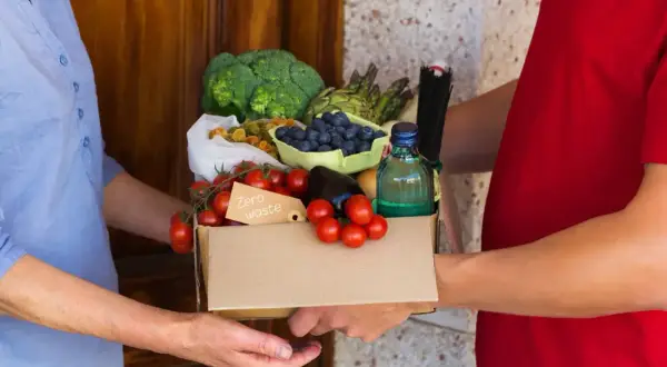 Dostawa dpd food: świeże warzywa, owoce i makaron w kartonie z napisem "Zero waste".