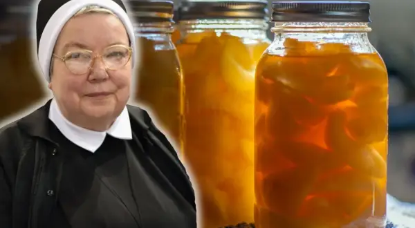 Siostra w okularach prezentuje słoiki z przetworzonymi gruszkami w occie.