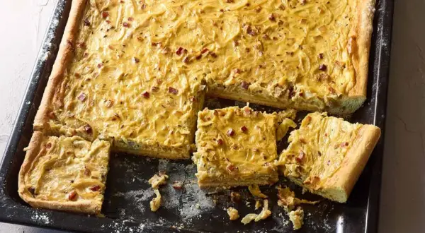 Herzhafter Zwiebelkuchen mit Speck, perfekt für ein gemütliches Abendessen. Hier ist ein einfaches Zwiebelkuchen Rezept.