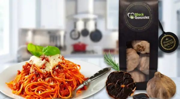 Spaghetti mit Tomatensoße, daneben eine Packung schwarzer Knoblauch und ganze Knoblauchzehen. Perfekt für schwarzer Knoblauch Rezepte.