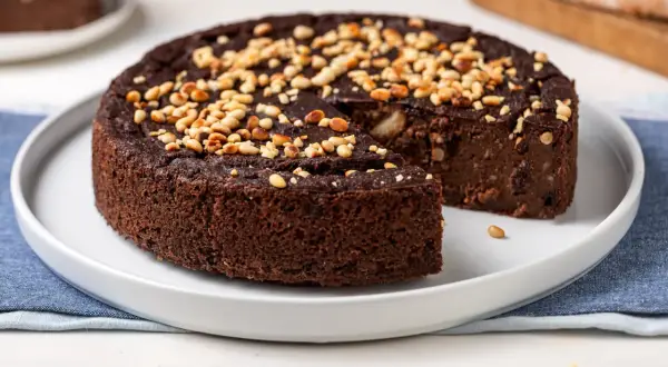 Torta di pane al cioccolato, soffice e ricca, guarnita con pinoli tostati. Un dolce goloso che profuma di casa.