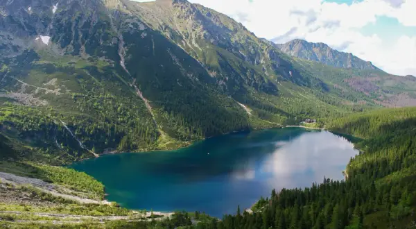Morskie Oko, największe jezioro w Tatrach, otoczone zielonymi lasami i skalistymi szczytami.