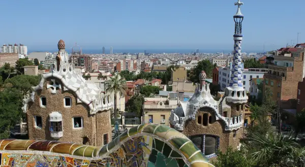 Widok na Park Güell w Barcelonie, z mozaikowymi budynkami i panoramą miasta. Ceny w Barcelonie mogą być wysokie, ale widoki są bezcenne.