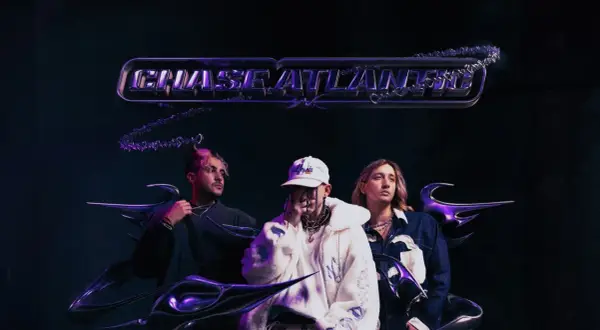 Trzech artystów z zespołu Chase Atlantic na mrocznym tle, gotowych na koncert.