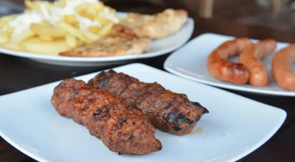 Grillowane kiełbaski i mięso mielone, klasyczne rumuńskie jedzenie, podane z frytkami i pieczywem.