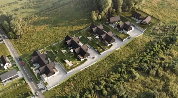 Nowoczesne domy z ciemnymi dachami i ogrodami, otoczone zielenią. Widok z lotu ptaka, jakby z **timelapse** pokazujący rozwój osiedla.