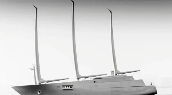 Un maestoso yacht a vela, un'opera di design firmata Philippe Starck, solca le acque con le sue tre imponenti vele.