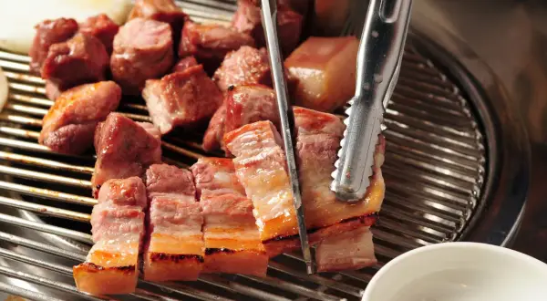 Kawałki boczku grillowane na ruszcie, cięte nożyczkami.