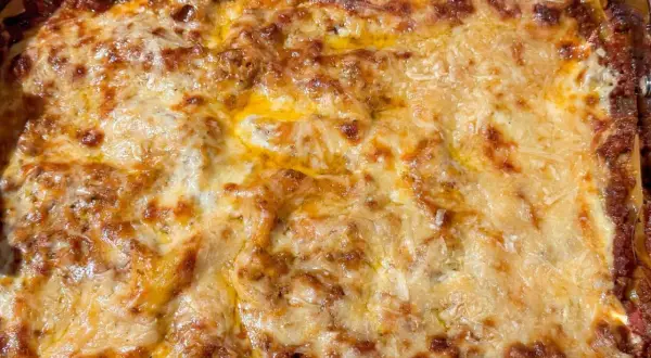 En gyllene, bubblande lasagne som precis kommit ur ugnen. Perfekt lasagne tid i ugn!
