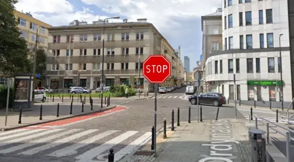 Widoczny znak stop na skrzyżowaniu ulic. Po prawej stronie budynek z napisem "Żabka".