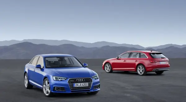 Dwa Audi A4: niebieski sedan i czerwony kombi, stoją na pustkowiu.