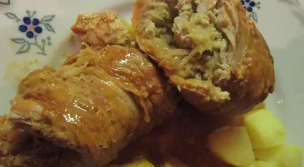 Zwei saftige Rouladen, gefüllt mit einer herzhaften Mischung, serviert mit Kartoffeln und einer köstlichen Sauce. Ein klassisches Gericht, das an ein deftiges Schnitzel mit Sauerkraut erinnert.