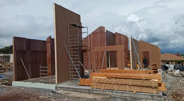 Construcción de casas entramado ligero con paneles prefabricados de madera. Andamios y materiales listos para seguir levantando las estructuras.