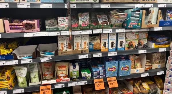 Półka z produktami bezglutenowymi: wafle, ciastka, muffiny, makarony i inne.