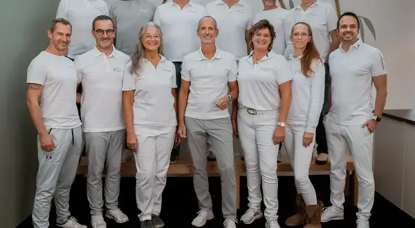 Teamfoto von Liebscher & Bracht. Die meisten tragen weiße Poloshirts und graue Hosen. Keine negativen Erfahrungen hier, nur ein motiviertes Team!