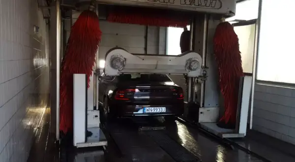 Samochód wjeżdża do myjni automatycznej. Czas dowiedzieć się, jak umyć samochód, by lśnił czystością!