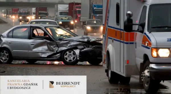 Wypadek w drodze do pracy. Zmiażdżony srebrny samochód i karetka na mokrej drodze.