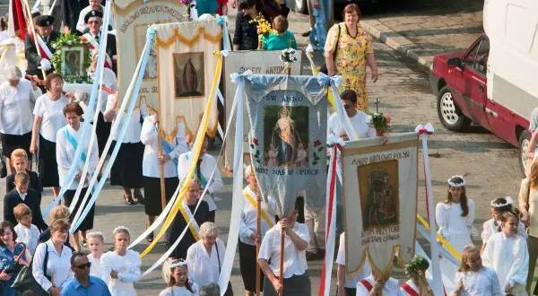 Procesja z chorągwiami religijnymi, 2 czerwca. Ludzie niosą obrazy Matki Bożej i świętych, uczestnicząc w uroczystości.