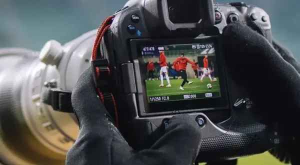 Aparat fotograficzny służy do uchwycenia dynamicznych momentów na boisku, jak ten piłkarz w akcji.