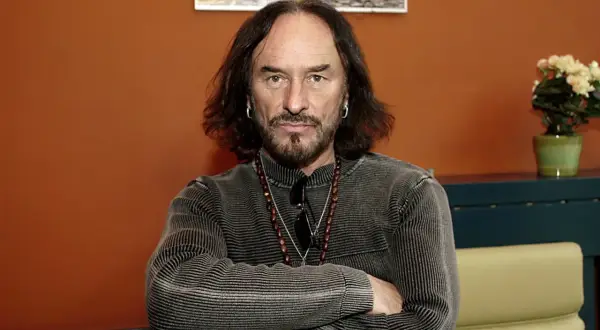 Stan Borys, artysta z charakterystyczną brodą i długimi włosami, siedzi z założonymi rękami. Jego piosenki, ułożone alfabetycznie, tworzą bogaty dorobek.