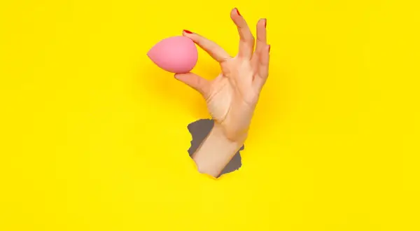 Mano con beauty blender rosa, un modo semplice per capire come pulire le beauty blender.