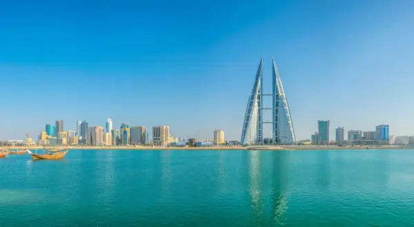 Manama Skyline mit dem Bahrain World Trade Center und traditionellen Dhaus-Booten am Khalifa Bin Salman Port.