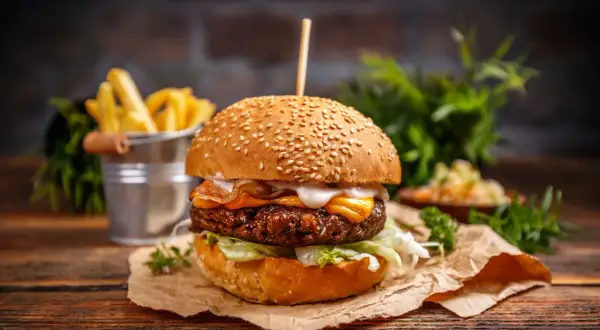 Soczysty burger z serem i boczkiem, idealny na grilla. Dowiedz się, jak przyprawić mięso na hamburgery, by uzyskać najlepszy smak.