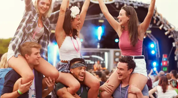Radosna ekipa na jednym z corocznych festiwali w Polsce. Dziewczyny siedzą na barana, bawiąc się przy muzyce.