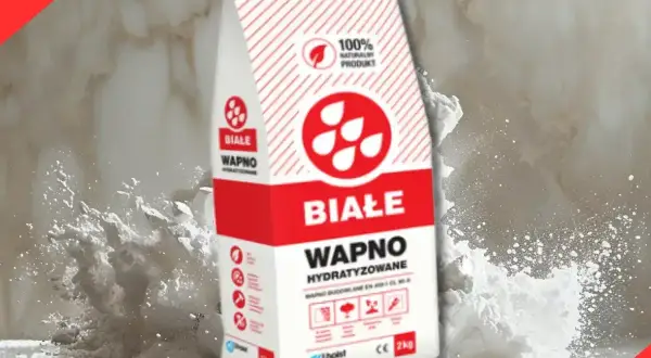 Białe wapno hydratyzowane w opakowaniu, otoczone chmurą białego pyłu. Idealne do prac budowlanych.