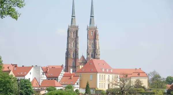 Zwei Türme des Domsinsel Breslau ragen über rote Dächer. Ein sonniger Tag über der Stadt.