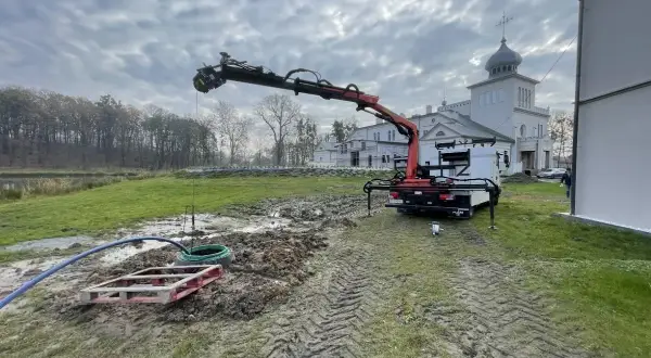 Dźwig z HDS pracuje przy studni, zapewniając własne ujęcie wody dla zabytkowego budynku.