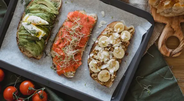 Trzy tosty na śniadanie: z awokado i jajkiem, łososiem i kiełkami, bananem i orzechami. Idealne, gdy zastanawiasz się, czym smarować chleb przy wysokim cholesterolu.