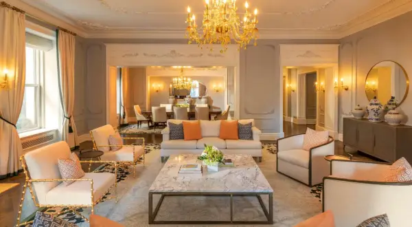 Elegancki salon z marmurowym stolikiem i złotym żyrandolem. Zastanawiasz się, ile kosztuje doba w hotelu Plaza w Nowym Jorku?