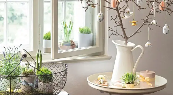 Osterdeko-Ideen: Ein Zweig mit Ostereiern und Frühlingsgrün am Fenster. Ab wann kann man diese Deko aufstellen?