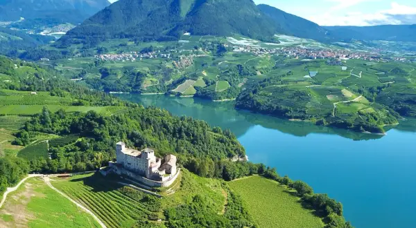 Castello di Tione, vigneti e lago in Val di Non. Un panorama mozzafiato, ideale per scoprire cosa vedere in questa valle incantevole.