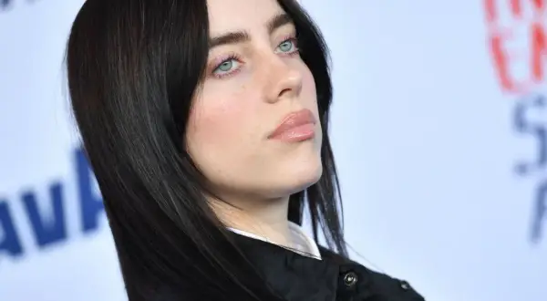 Billie Eilish z niebieskimi oczami i ciemnymi włosami. Zastanawiasz się, ile kosztuje bilet na koncert Billie Eilish?