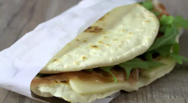 Leckeres Piadina Rezept: Fladenbrot gefüllt mit Schinken, Käse und Rucola, perfekt für unterwegs.