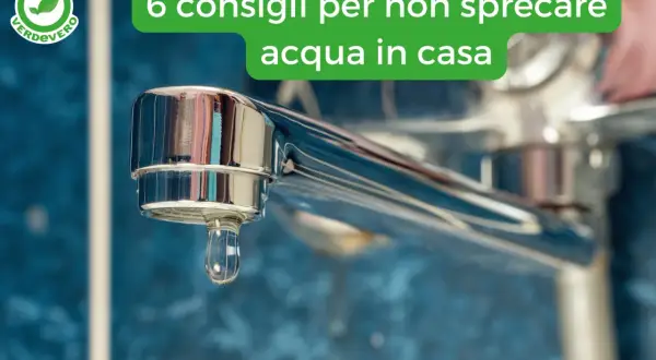 Goccia d'acqua che cade da un rubinetto cromato, simbolo di spreco d'acqua in casa.